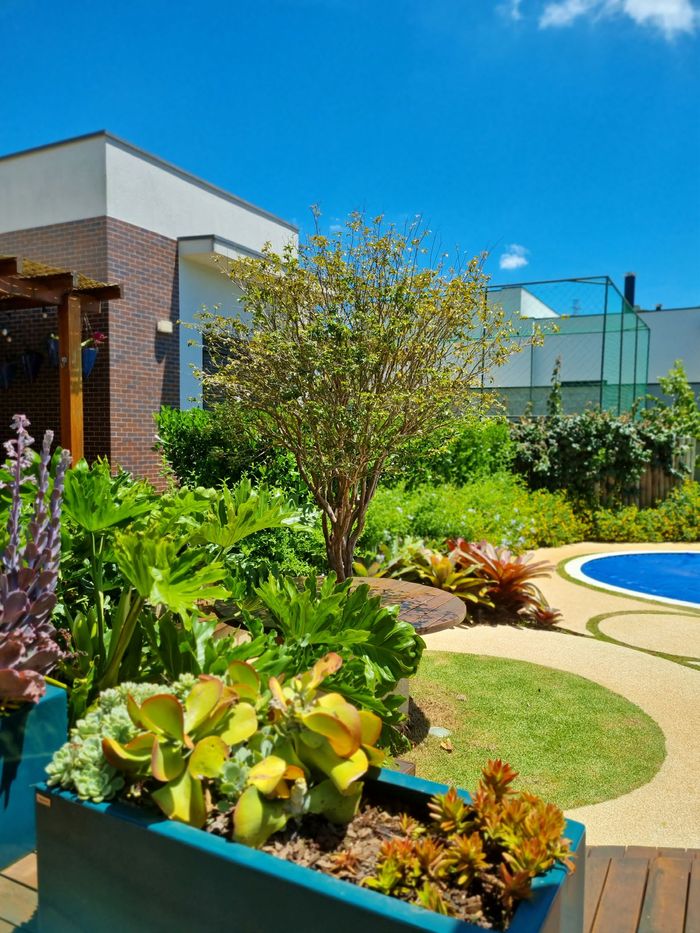 Jardim com pergolado e piscina